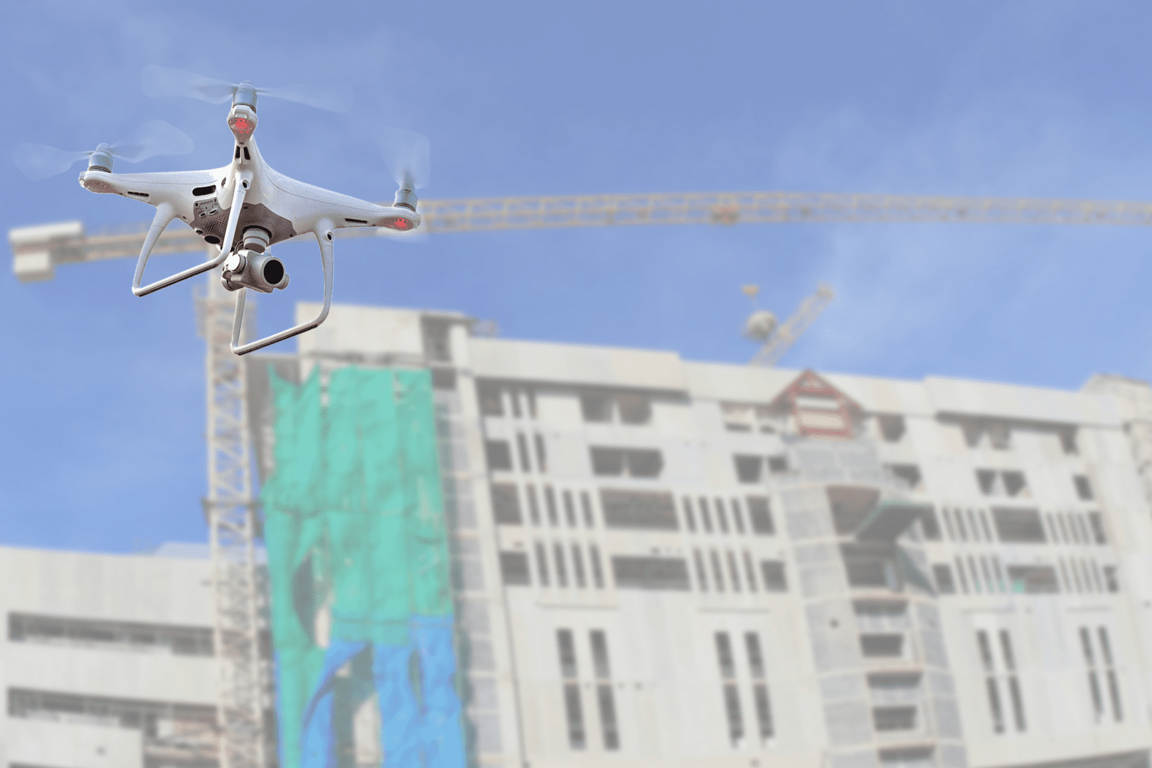 A white and blue helicopter flying over a building.